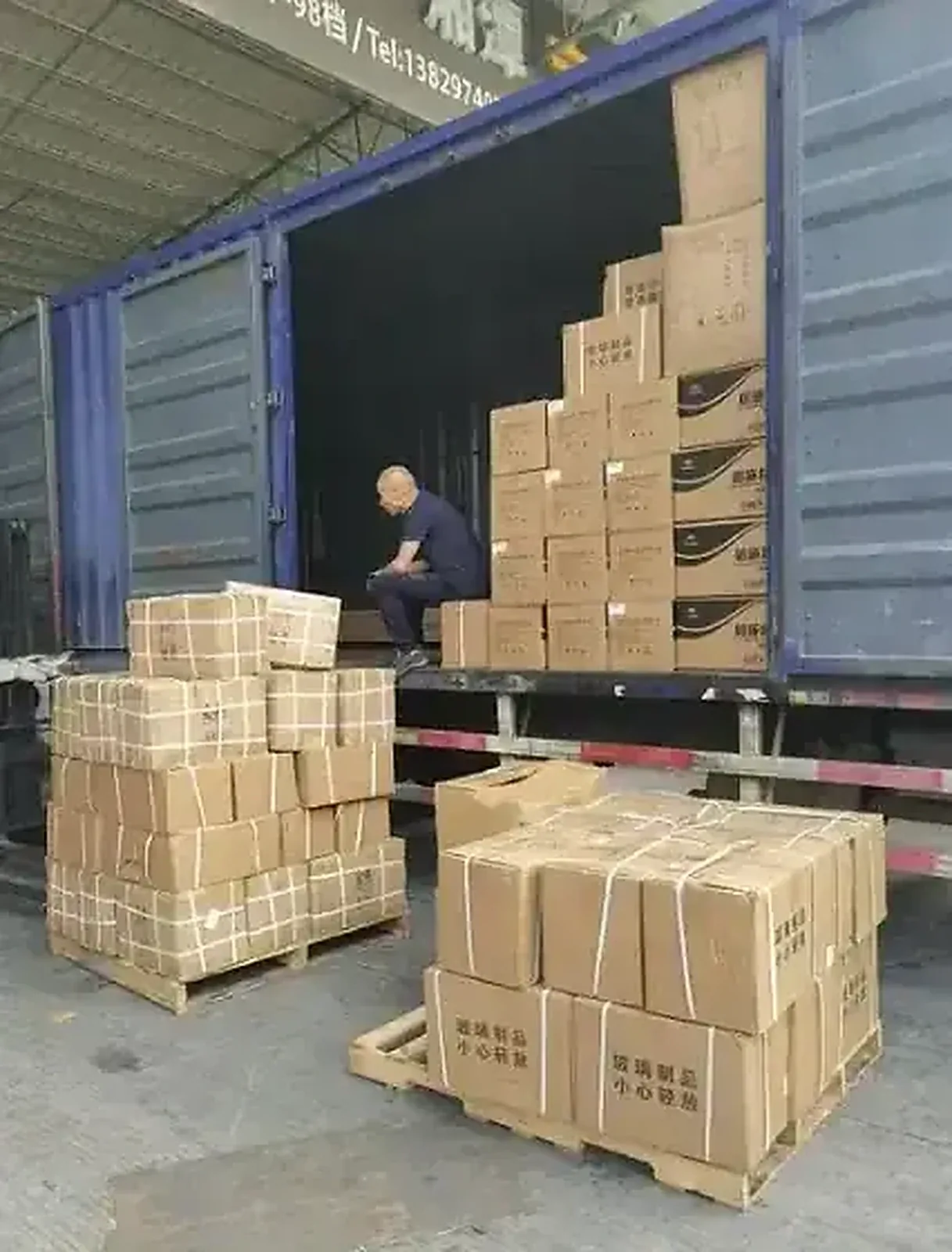 Loading strapped cartons into a container
