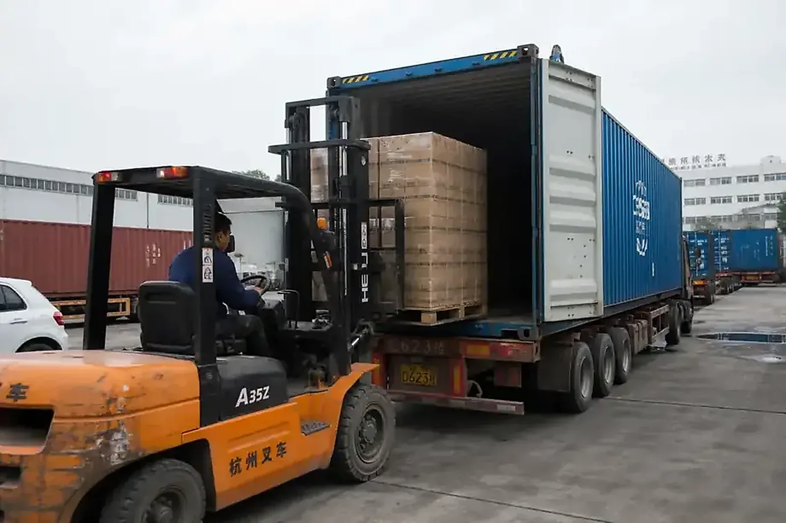 Forklift loading pallets into a shipping container